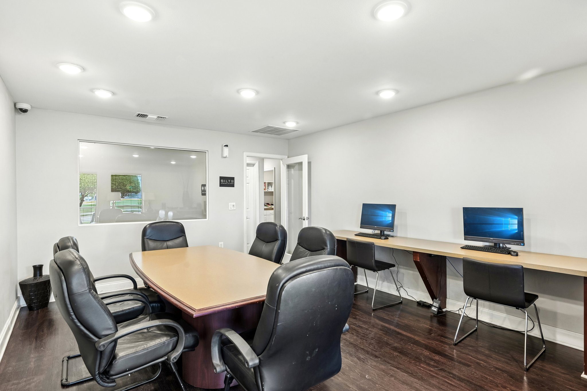 A conference room with a long table and chairs.